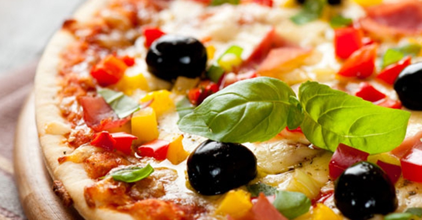 Pizza colorata con peperoni, olive nere, basilico fresco – forno a legna